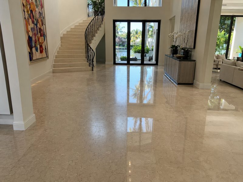 Polished marble entry hall reflecting daylight from the doorway